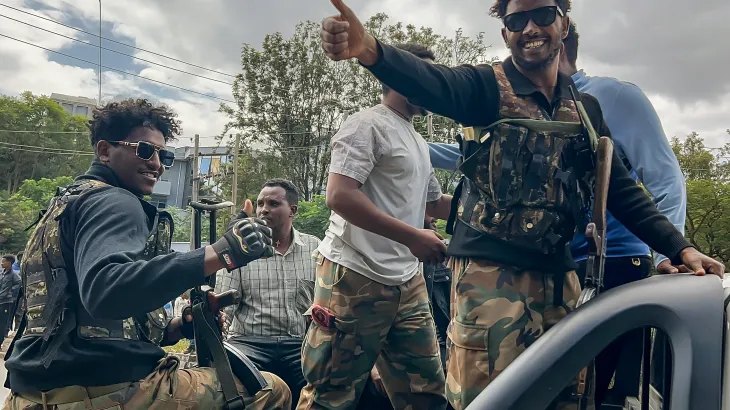 Members of the Ethiopian pro-government Tigray Peace Force (TPF) gesture as residents welcome them while they ride in a pickup truck during a street patrol after Ethiopian federal and allied forces entered the Tigray capital of Mekelle, on October 4, 2026.