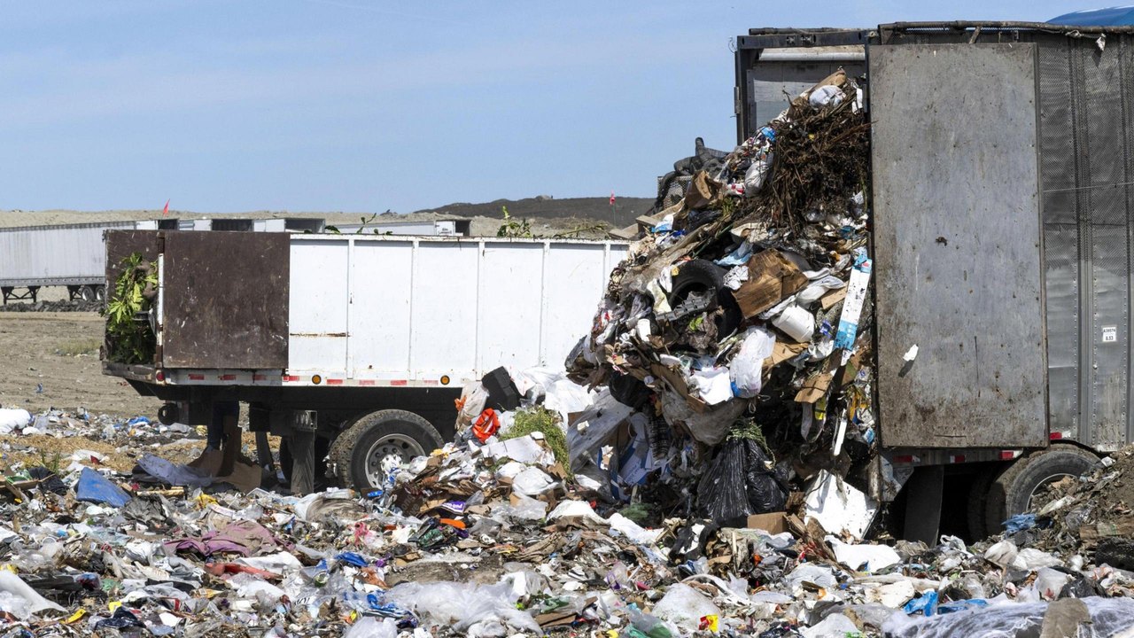 Trucks dump rubbish at a landfill in California.