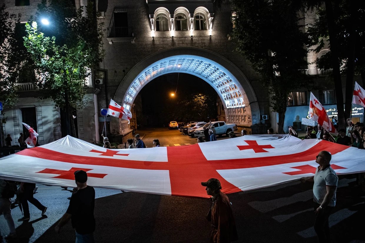 Protestors hold a Georgian flag during a march in October 2026. Photo: Mariam Nikuradze/OC Media.