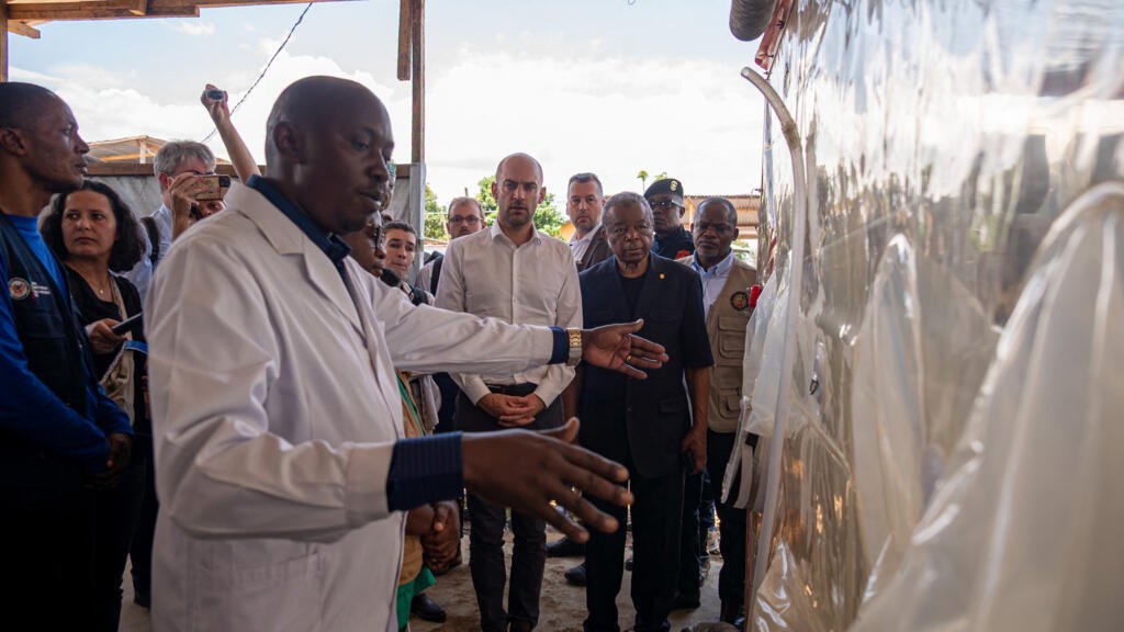 Jean-Noël Barrot (C), France's Minister for Europe and Foreign Affairs, visits the Ebola Treatment Centre Rwanpara in Bunia to express France's support for those involved in the response to the outbreak on 3 October, 2026.