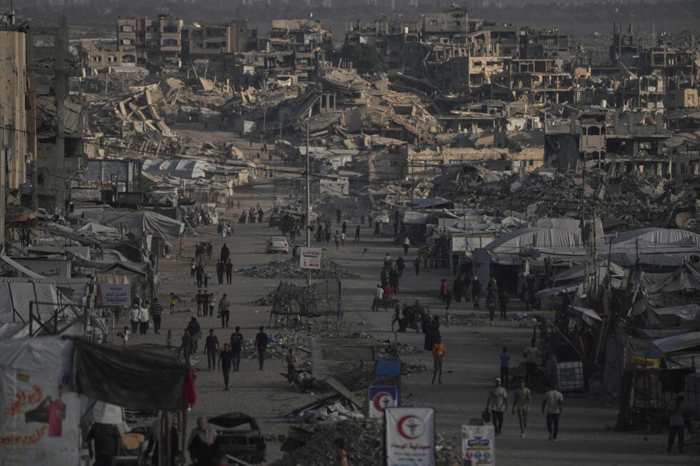 Palestinians walk along a street lined with buildings destroyed during the Israel-Hamas war in Gaza City