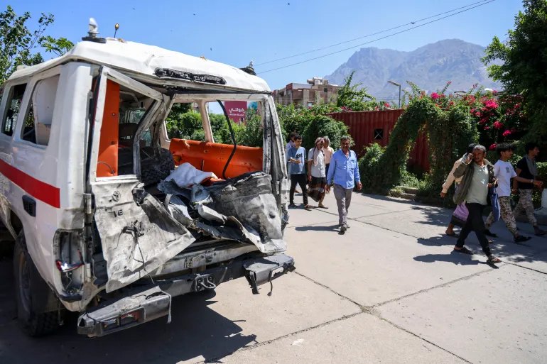 Yemeni people inspect a damaged ambulance in front of Al-Thawra General Hospital in Taiz on October 22, 2026, after it was towed from Al-Shaqab front in Sabir Al-Mawadim district, south of Taiz, where it was reportedly targeted the day before while carrying wounded people during battles between Saudi-backed Yemeni government fighters and Yemen's Iran-backed Houthis. The Saudi-led coalition fighting the Houthis has launched hundreds of raids in Yemen backing the internationally recognised governm