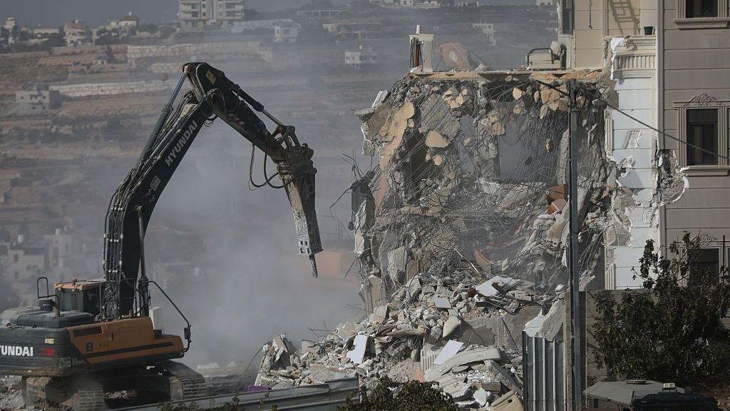 Digger destroys house. Rubble, dust and concrete.