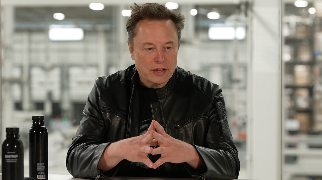 Elon Musk, in a black leather jacket, speaking about SpaceX's quarterly business performance in a livestream.