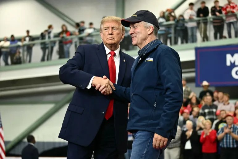 US President Donald Trump shakes hands with US Senator Dan Sullivan (R-AK) as he invited him to speak during a campaign rally at Curtis D. Menard Memorial Sports Center in Wasilla, Alaska, on October 13, 2026.