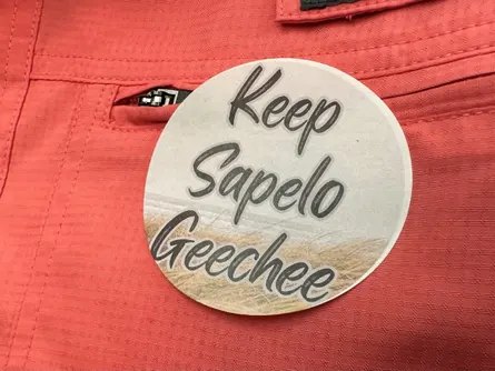 A sticker saying “Keep Sapelo Geechee” on red cloth