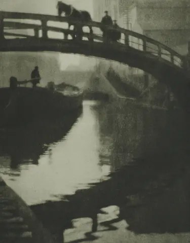 A horse and figures cross an arched bridge over Regent’s Canal, with reflections below