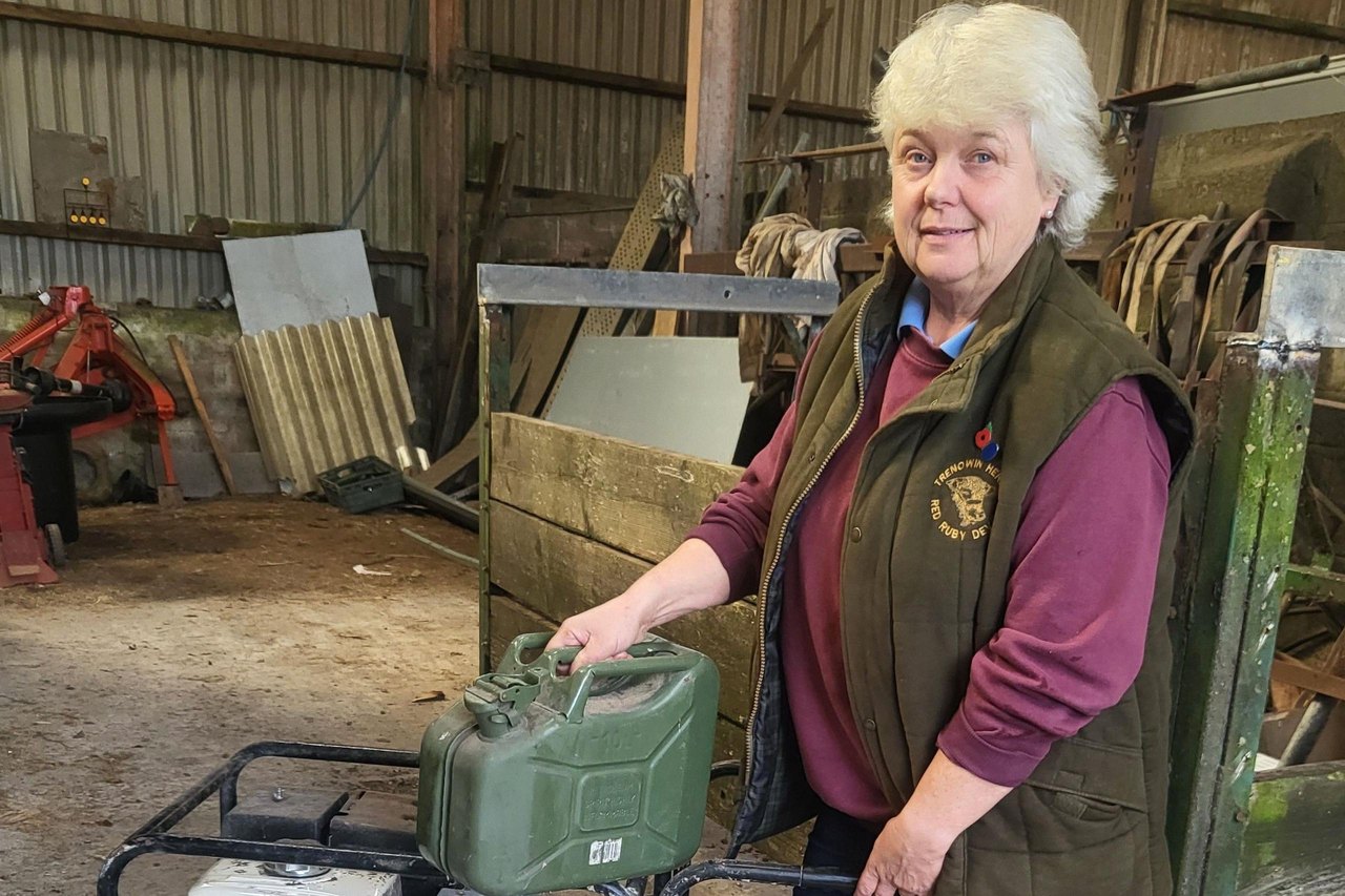 Bridgette Clamp with her electricity generator wearing a green body warmer and maroon jumoer